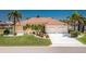 Charming yellow home featuring a tile roof, a well-manicured lawn, and a two-car garage, all under a bright blue sky at 910 Via Tripoli, Punta Gorda, FL 33950