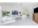 Bright and airy living room with white sofas, glass coffee table, and vaulted ceilings at 910 Via Tripoli, Punta Gorda, FL 33950