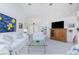 Spacious living room featuring white furniture, bright artwork, and views into the adjacent dining area at 910 Via Tripoli, Punta Gorda, FL 33950