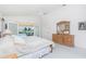 Bright main bedroom featuring vaulted ceilings, ceiling fan, and ensuite bath with pool views through sliding glass doors at 910 Via Tripoli, Punta Gorda, FL 33950