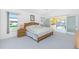 Airy main bedroom with light wood furniture, pool views, and ceiling fan at 910 Via Tripoli, Punta Gorda, FL 33950