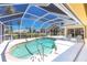 Screened in pool area with clear blue water, patio furniture, and view of lush tropical landscaping at 910 Via Tripoli, Punta Gorda, FL 33950