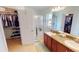 Bathroom featuring a dual sink vanity, walk-in shower, and access to a walk-in closet at 10068 Winding River Rd, Punta Gorda, FL 33950