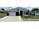 Charming single-story home with well-manicured lawn, black door, and attached garage at 10068 Winding River Rd, Punta Gorda, FL 33950