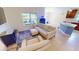 Bright living room with a comfortable white sofa set, an aquarium, and seamless flow to the kitchen at 10068 Winding River Rd, Punta Gorda, FL 33950