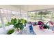 Serene sunroom offering a tranquil retreat with sheer curtains and lush greenery, perfect for relaxation at 10068 Winding River Rd, Punta Gorda, FL 33950