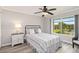 Cozy bedroom with a black iron bed frame, a large window with a pool view, and a ceiling fan at 1080 Bal Harbor Blvd # 11C, Punta Gorda, FL 33950