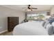 Bright bedroom featuring a sliding glass door, ceiling fan, and dark wood dresser at 1080 Bal Harbor Blvd # 11C, Punta Gorda, FL 33950