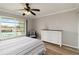 This bedroom features a large window with a pool view, a ceiling fan, and a white dresser at 1080 Bal Harbor Blvd # 11C, Punta Gorda, FL 33950