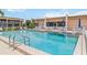 Beautiful community pool area with blue umbrellas and comfortable seating for residents at 1080 Bal Harbor Blvd # 11C, Punta Gorda, FL 33950
