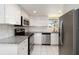 Modern kitchen featuring granite counters, tiled backsplash, stainless appliances and white cabinets at 1080 Bal Harbor Blvd # 11C, Punta Gorda, FL 33950