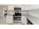 Close up of modern kitchen featuring granite counters, tiled backsplash, stainless oven and microwave at 1080 Bal Harbor Blvd # 11C, Punta Gorda, FL 33950