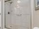 Clean shower with white tiled walls, glass door, and contrasting mosaic floor tiles at 1080 Bal Harbor Blvd # 11C, Punta Gorda, FL 33950