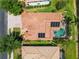 Aerial view of the home showcasing solar panels, pool, screened enclosure and clay tile roof at 11982 Granite Woods Loop, Venice, FL 34292