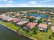 Aerial view of home with a pool overlooking the lake in a neighborhood with lush landscaping at 11982 Granite Woods Loop, Venice, FL 34292