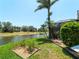 Lush backyard featuring a scenic waterfront view with a screened enclosure blending indoor/outdoor living seamlessly at 11982 Granite Woods Loop, Venice, FL 34292