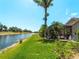 The backyard boasts a scenic waterfront view and lush landscaping, great for outdoor enjoyment at 11982 Granite Woods Loop, Venice, FL 34292