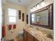 Well-lit bathroom featuring granite countertop vanity, decorative wall art, and glass-enclosed shower at 11982 Granite Woods Loop, Venice, FL 34292