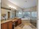 Bathroom featuring double vanities, granite countertops, and a separate tub and shower at 11982 Granite Woods Loop, Venice, FL 34292
