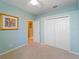 Small bedroom featuring light blue walls, carpeted floors, and a closet at 11982 Granite Woods Loop, Venice, FL 34292