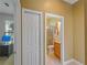 Hallway view with doors leading to other rooms, including a bathroom with glass shower at 11982 Granite Woods Loop, Venice, FL 34292