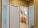 Hallway view with doors leading to other rooms, including a bathroom with granite counters and wood cabinetry at 11982 Granite Woods Loop, Venice, FL 34292