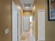 Hallway view with doors leading to other rooms and tile flooring throughout the space at 11982 Granite Woods Loop, Venice, FL 34292