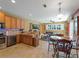 Open kitchen boasts wood cabinets, granite countertops, breakfast bar and a view to living area at 11982 Granite Woods Loop, Venice, FL 34292