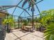 Screened lanai with a dining table, chairs and views of the beautiful lake and backyard at 11982 Granite Woods Loop, Venice, FL 34292