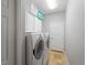 Functional laundry room with a full-size washer and dryer and storage cabinets at 11982 Granite Woods Loop, Venice, FL 34292