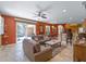 Open-concept living room featuring a cozy sitting area, access to outdoor pool, and adjacent kitchen and dining spaces at 11982 Granite Woods Loop, Venice, FL 34292