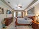 Cozy main bedroom featuring a wooden sleigh bed, neutral tones, and access to outdoor views at 11982 Granite Woods Loop, Venice, FL 34292