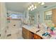 A cozy bathroom with vanity, a mirror, bathtub, and tiled shower at 12018 Saragossa Ln, North Port, FL 34287