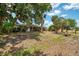 Front yard with mature trees and a well-maintained lawn at 12018 Saragossa Ln, North Port, FL 34287