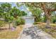 Detached one-car garage with a concrete driveway and mature shade trees at 12018 Saragossa Ln, North Port, FL 34287