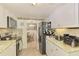 Bright kitchen with white cabinets, stone countertops, and stainless steel appliances at 12018 Saragossa Ln, North Port, FL 34287