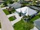 Aerial view showcasing the home's modern roof, paved driveway, manicured lawn, and elegant landscaping at 1306 Osprey Dr, Punta Gorda, FL 33950