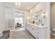 Bright bathroom featuring a double vanity, white cabinets, and a chandelier above a textured rug at 1306 Osprey Dr, Punta Gorda, FL 33950