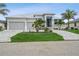 Beautiful single-story home with a three-car garage, manicured lawn, and palm trees at 1306 Osprey Dr, Punta Gorda, FL 33950
