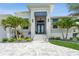 Inviting front entrance with blue double doors, palm trees, and lush landscaping at 1306 Osprey Dr, Punta Gorda, FL 33950