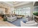 Open-concept living room with a large sectional, modern ceiling fan, and sliding glass doors to the lanai at 1306 Osprey Dr, Punta Gorda, FL 33950