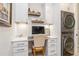 Functional office nook with custom cabinets, floating shelves, integrated lighting and stacked washer-dryer at 1306 Osprey Dr, Punta Gorda, FL 33950