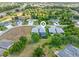 Aerial view of the back of a house, highlighting its screened pool, landscaping, and surrounding greenery at 1327 Hedgewood Cir, North Port, FL 34288