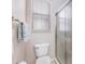 Bathroom with a frosted glass shower door and a window with blinds, providing natural light and privacy at 1327 Hedgewood Cir, North Port, FL 34288