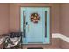 A welcoming light blue front door is decorated with a wreath and decorative side lights at 1327 Hedgewood Cir, North Port, FL 34288
