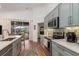 Kitchen with stainless appliances, light counters, and view through sliding doors to pool at 1327 Hedgewood Cir, North Port, FL 34288