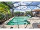 Relaxing screened pool surrounded by lush landscaping and blue skies, offering privacy at 1327 Hedgewood Cir, North Port, FL 34288