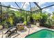 Outdoor screened pool features a conversation area with fire pit at 1327 Hedgewood Cir, North Port, FL 34288