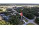 An aerial view of a single-Gathering home surrounded by lush trees and a well manicured lawn at 14534 Keene Ave, Port Charlotte, FL 33953