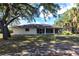 Back exterior showing a cozy screened-in lanai and a well-kept lawn, perfect for relaxation and entertainment at 14534 Keene Ave, Port Charlotte, FL 33953